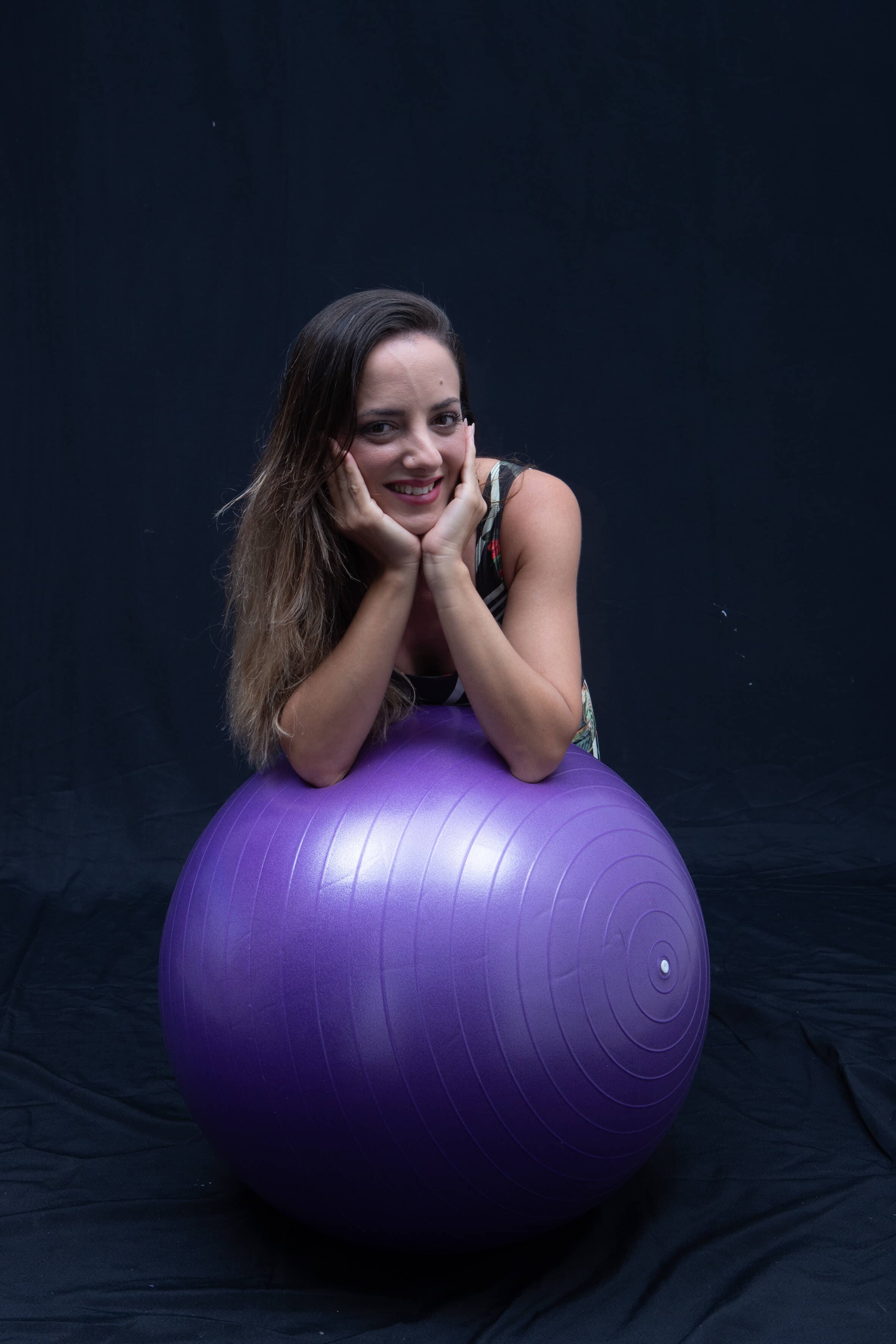 Mulher praticando Pilates com bola suíça no Studio Motri, Studio de Pilates em Lauro de Freitas