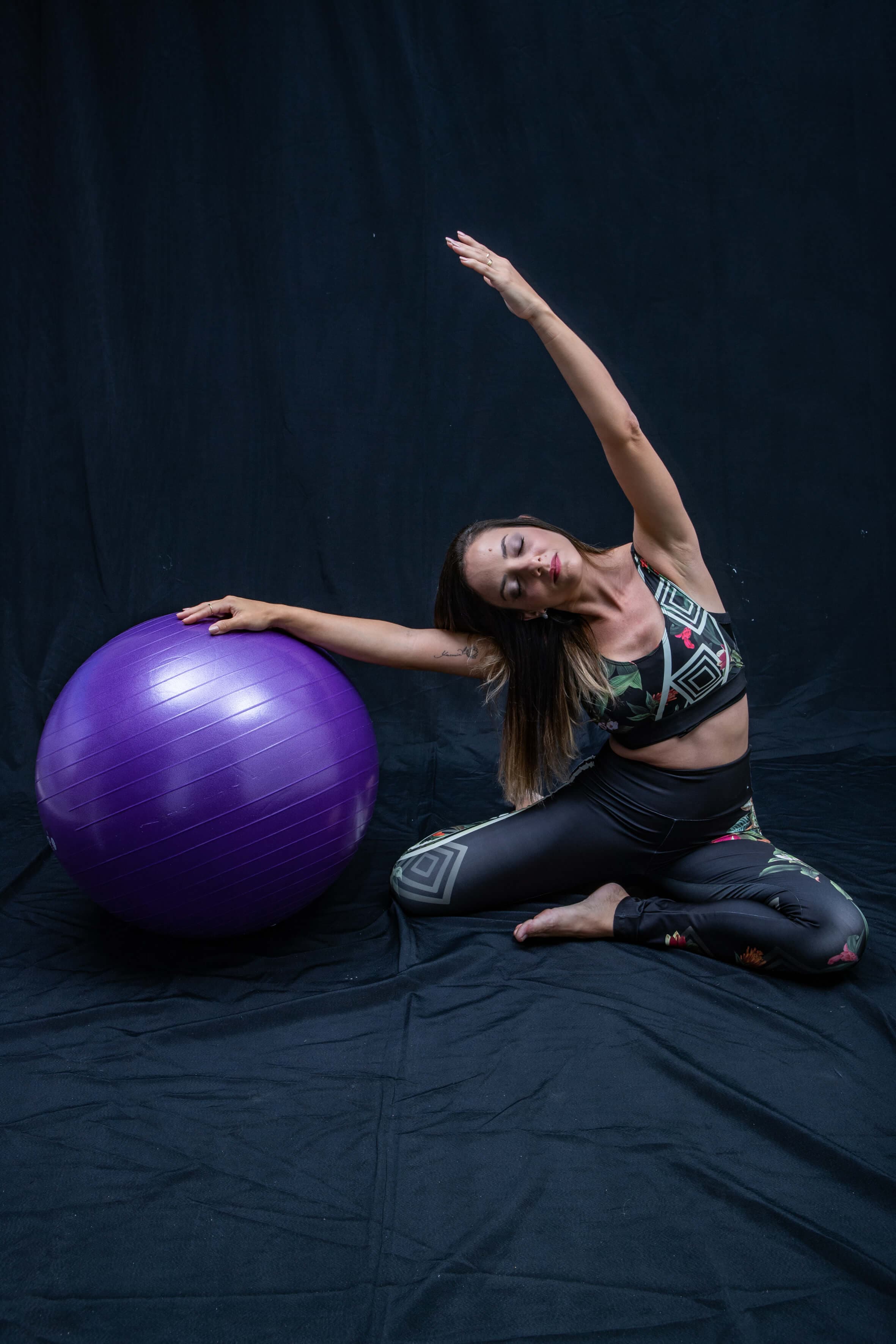 Mulher praticando Pilates com bola suíça no Studio Motri, Studio de Pilates em Vilas do Atlântico