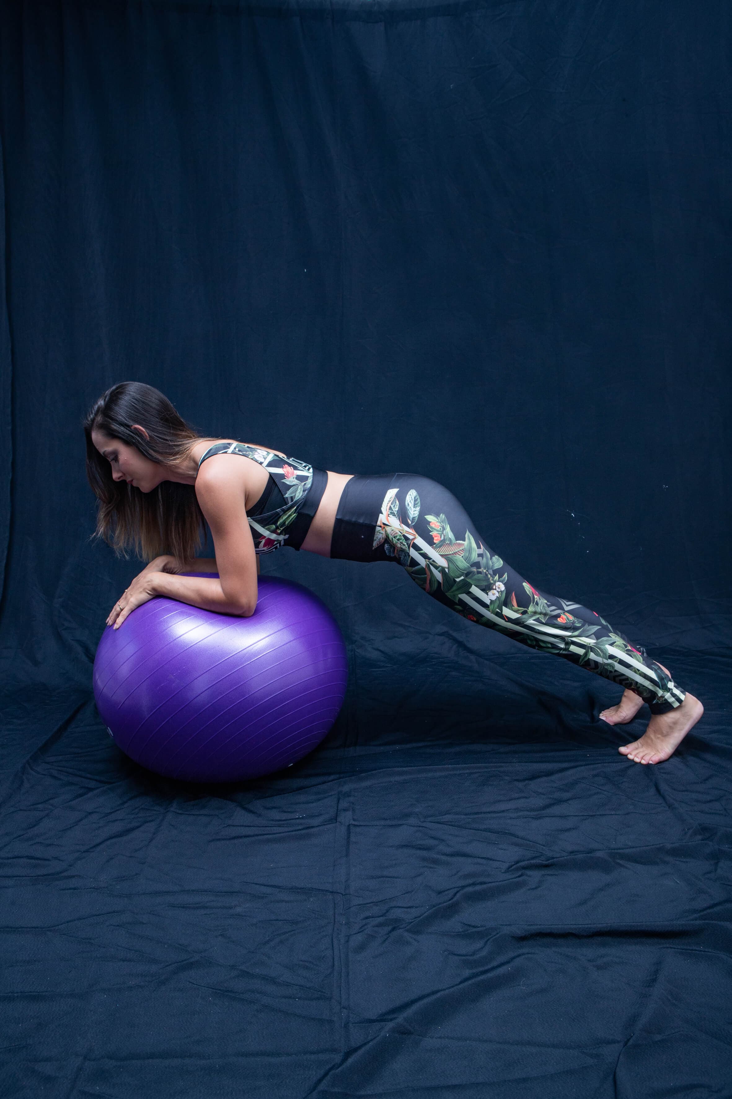 Mulher praticando Pilates com bola suíça, Pilates Clássico, Pilates Clínico